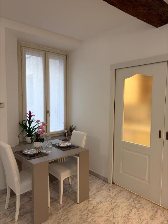 a dining room with a table and chairs and a door at Suite romantica a Como Centro in Como