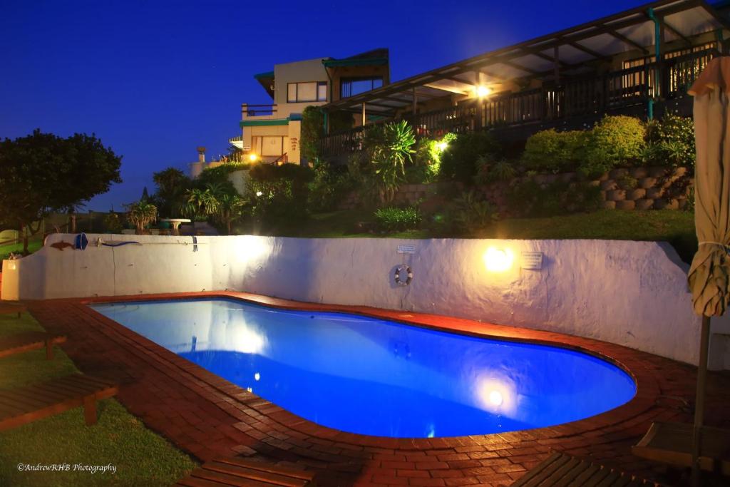 a swimming pool in a backyard at night at Breakerview in Shelly Beach