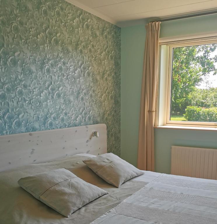 a bedroom with a white bed with a window at TheGilgahouse Gardenroom nr 2 in Nakskov