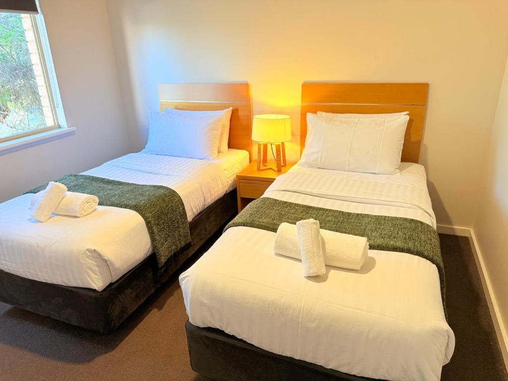 a bedroom with two beds with towels on them at Fairway Retreat in The Vines