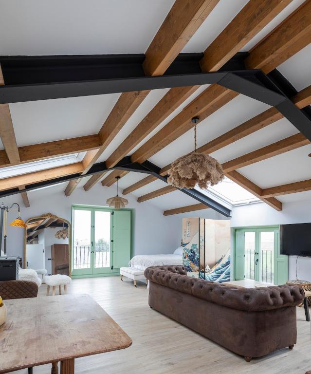 a living room with wooden ceilings and a couch at El Sueño, La Perla in Barres
