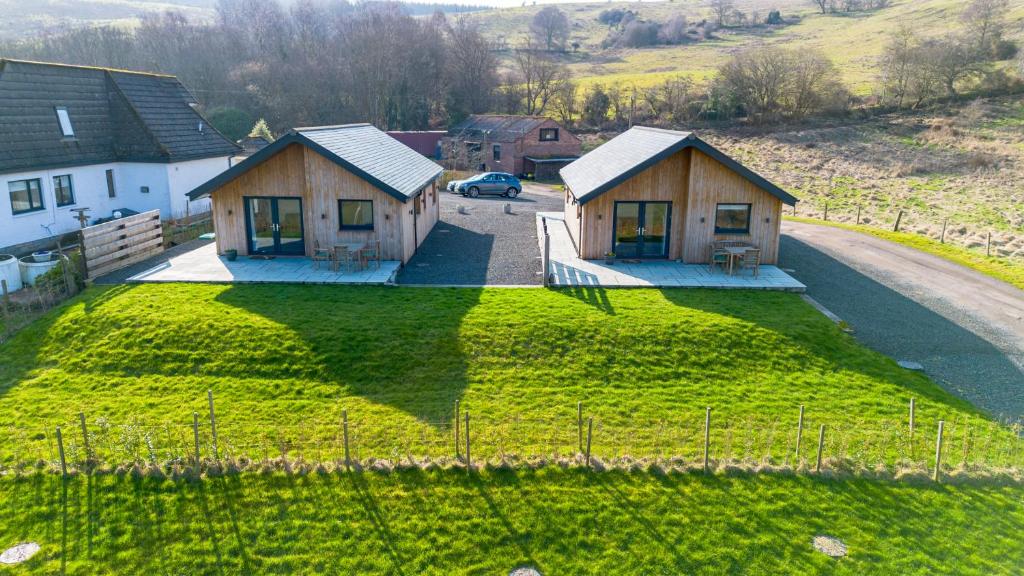 an aerial view of two houses on a grass field at Annabella Cottages in Crossford