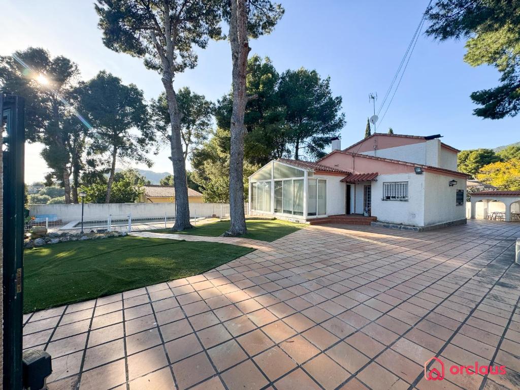 a brick driveway with a white building and trees at Villa Las Palmas in Benicàssim