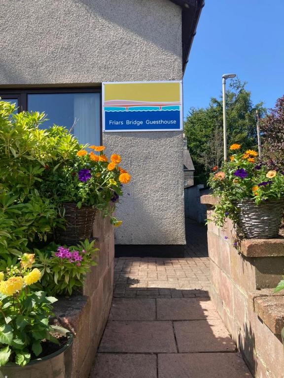 a building with some flowers in front of it at Friars Bridge Guesthouse in Inverness