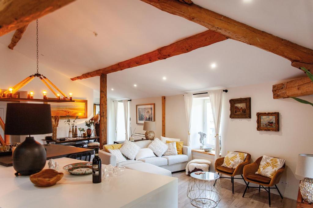 a living room with white furniture and wooden beams at Résidence Espéraza ADULTS ONLY in Espéraza