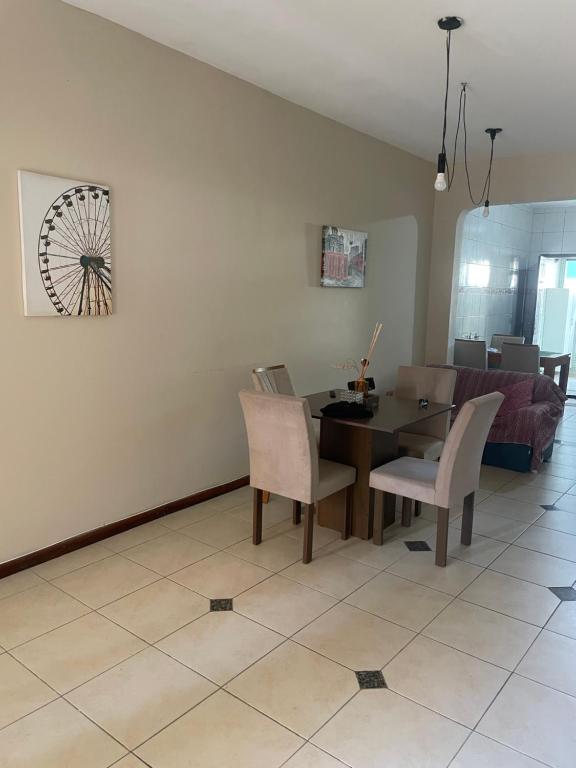 a dining room with a table and chairs and a couch at casa tres quartos condominio aeroporto lazer praias mercados a poucos minutos in Salvador
