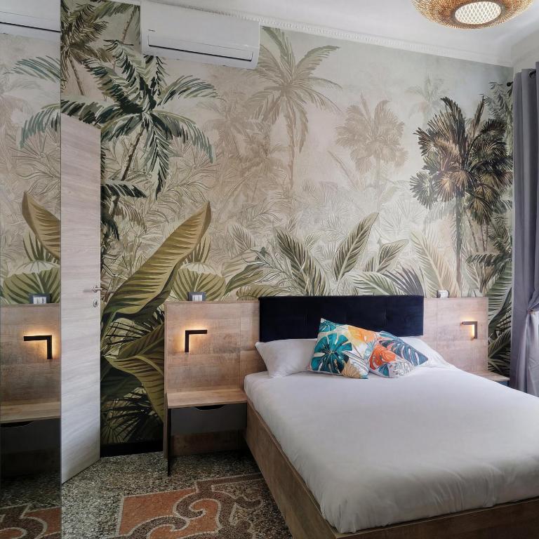 a bedroom with a bed with a tropical wallpaper at Janua Jungle House in Genoa