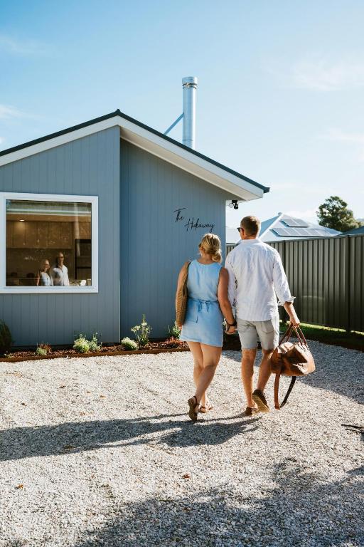 a man and a woman walking past a building at The Hideaway on McFarlane, Mudgee in Mudgee