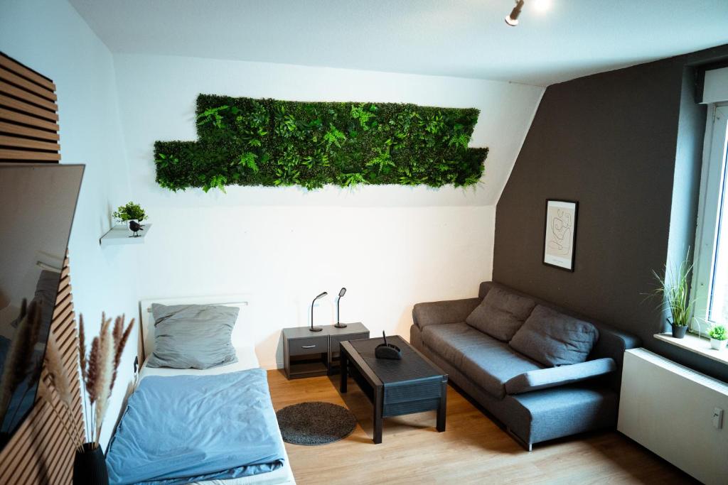 a living room with a couch and a plant on the wall at Wohnung am See in Wetter