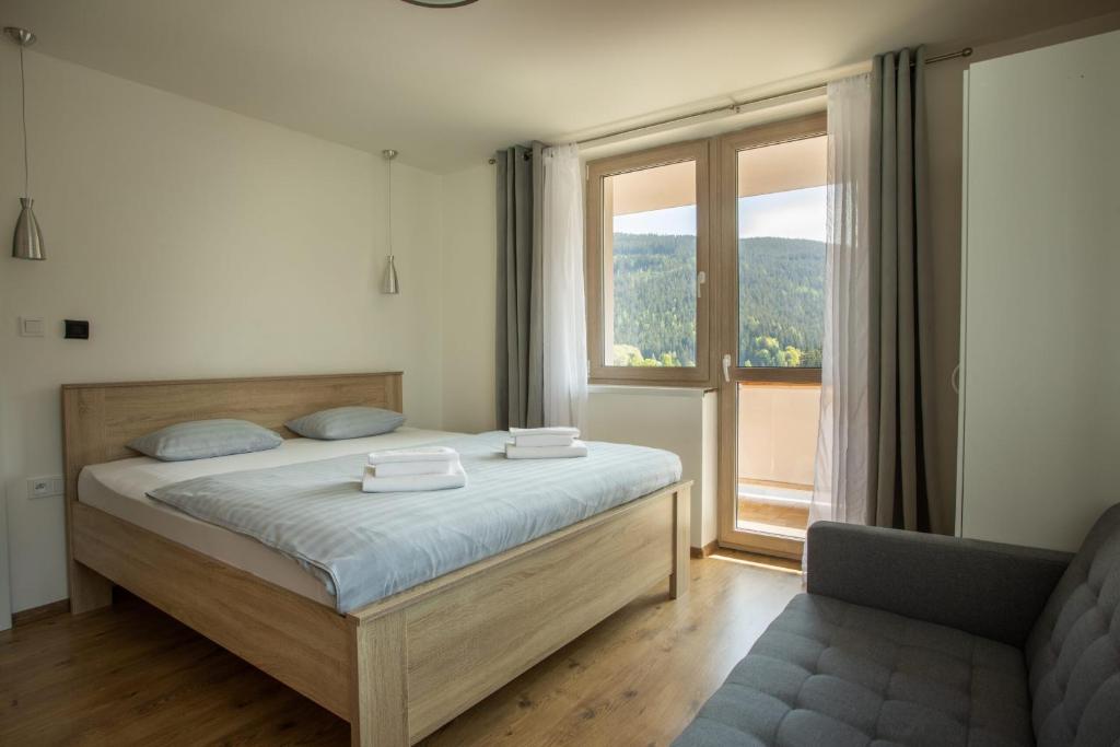 a bedroom with a bed and a large window at Apartmány Pec pod Sněžkou in Pec pod Sněžkou