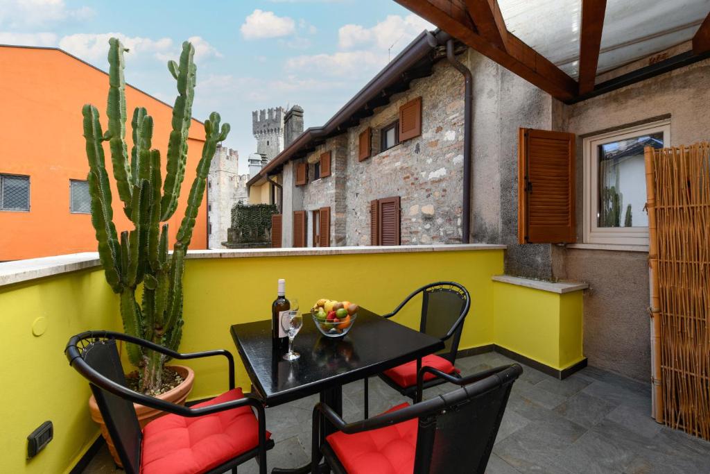 a table and chairs on a balcony with a cactus at Central Square in Sirmione