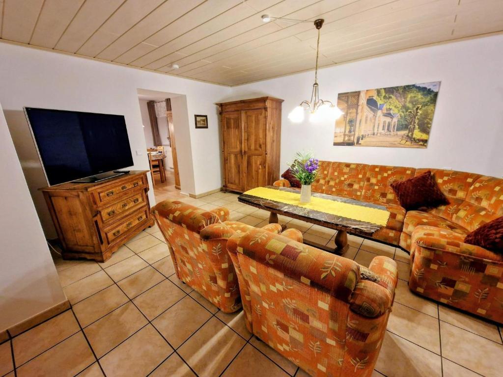a living room with a couch and a tv at Haus am Thiesenring in Bad Berneck im Fichtelgebirge