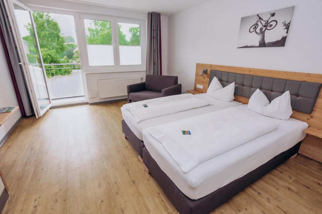a bedroom with a large bed and a chair at K1 Hotel Willingen in Willingen