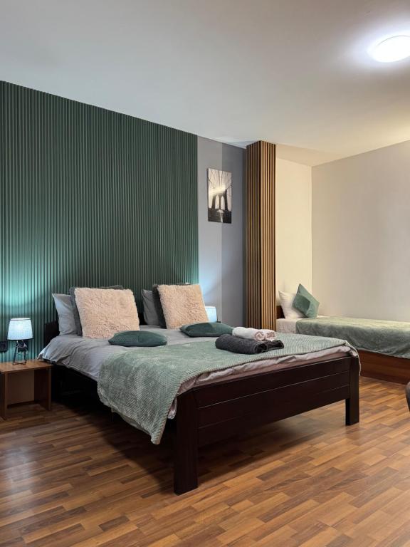 a bedroom with a bed and a green wall at Zulu Apartments and Studios in Kumanovo