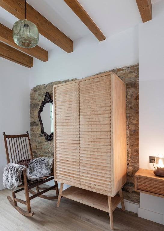 a room with a wooden chair and a large wooden shutter at El Sueño, Paca in Barres