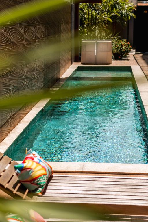 a swimming pool with a chaise lounge in a house at Easy Porto Hotel in Porto De Galinhas