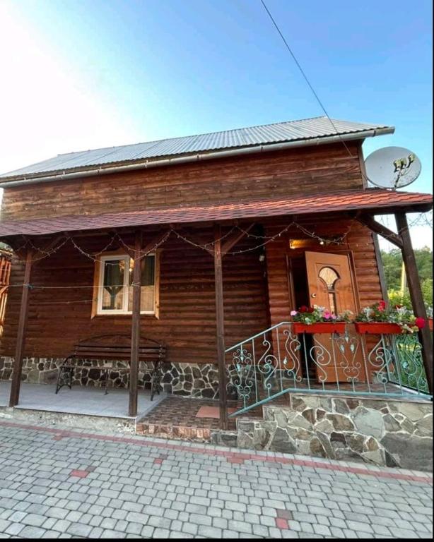 a log cabin with a porch and a balcony at Садиба У Коса in Pilipets