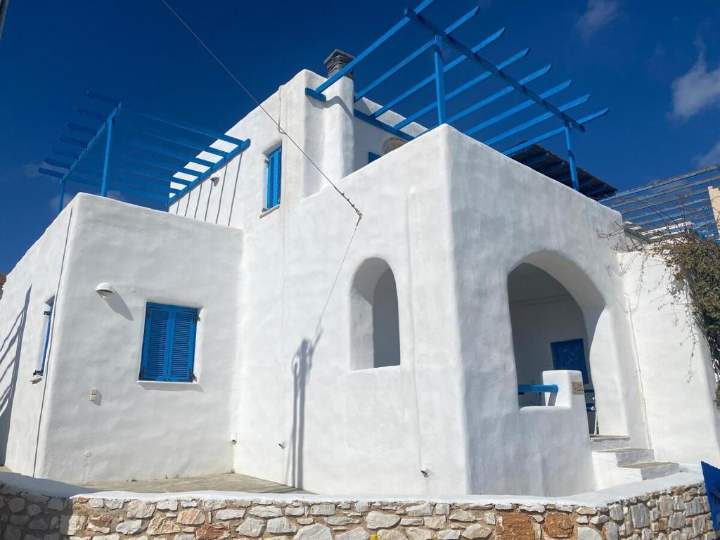 a white building with blue windows on top of it at Villa Effie in Aspro Chorio Paros