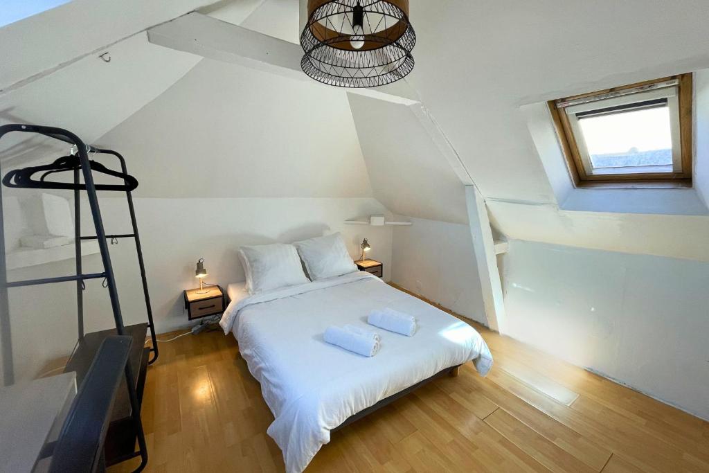 a bedroom with a white bed in a attic at L'Éclipse - Gare de Melun in Melun