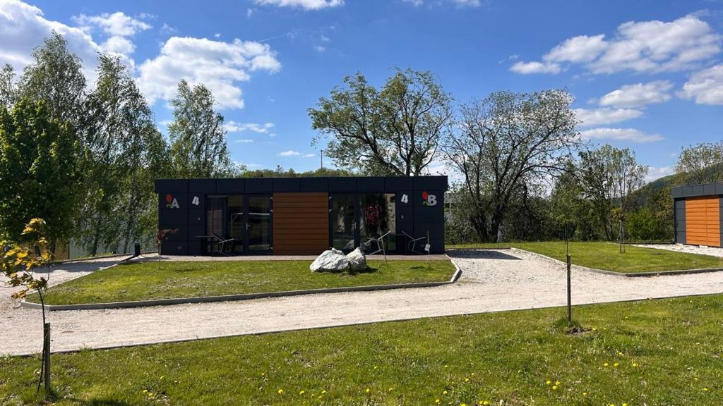 a black building with a cow statue in the grass at Apartmány Štramberk in Štramberk
