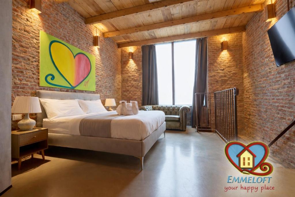 a bedroom with a bed in a brick wall at Emme Loft I Flower Moon - Boutique Loft with Jacuzzi in Milan
