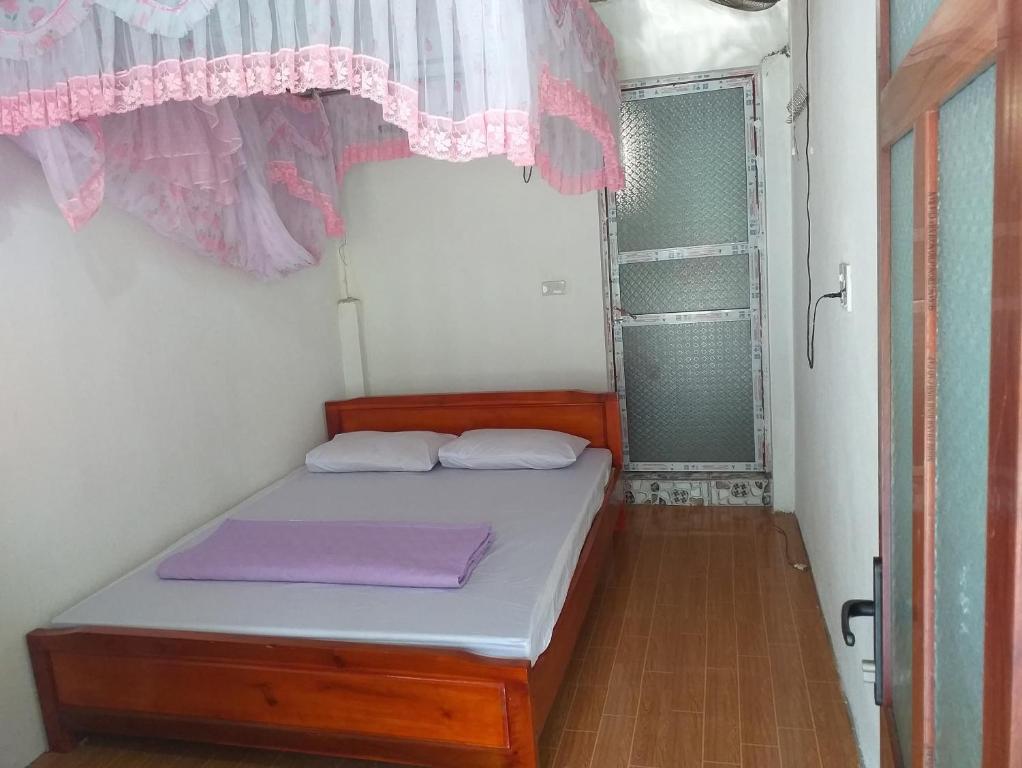 a small bed in a room with a window at Quang Hưng Hommestay in Pac Ngoi
