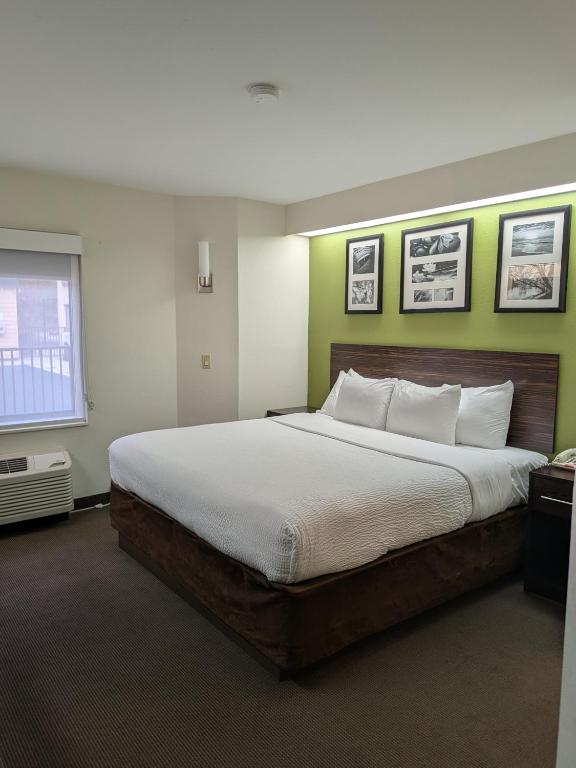 a bedroom with a large bed with green walls at Sleep Inn Bryson City - Cherokee Area in Bryson City