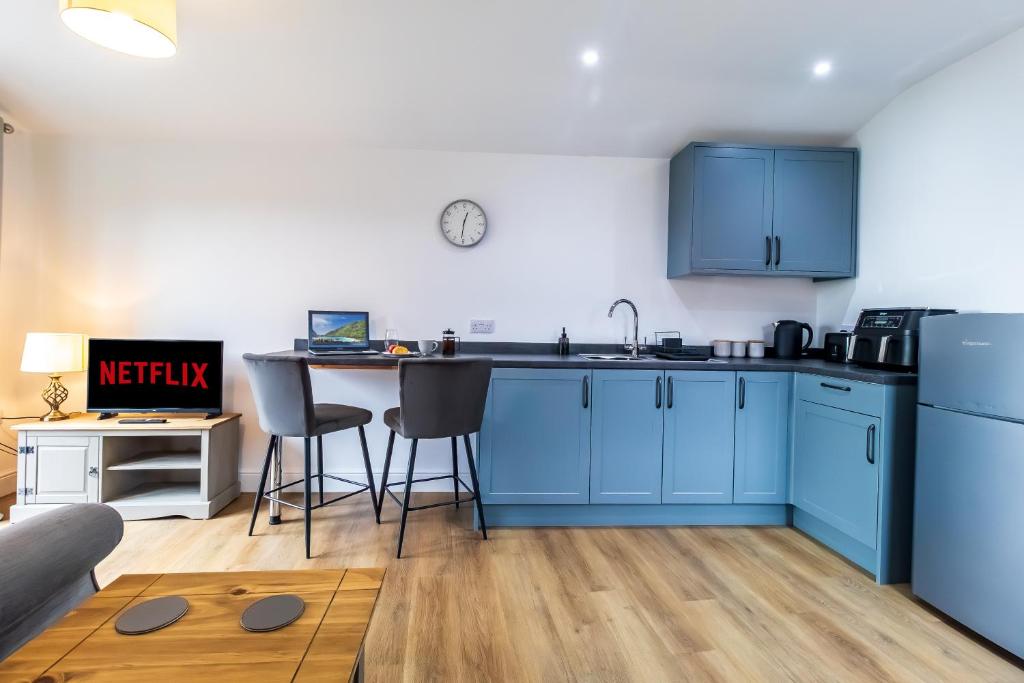 a kitchen with blue cabinets and a table at The Calf House in Sibbertoft