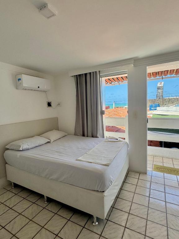 a bedroom with a bed with a view of the ocean at Pousada e Hostel Natal in Natal