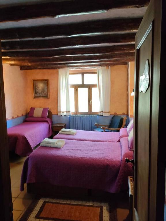 a bedroom with two beds and a window at Casa Rural El Ensueño in Caneto