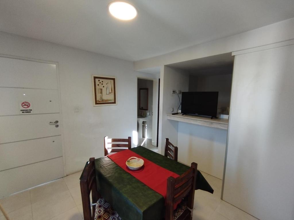 a small dining room with a table and a television at Complejo EyE in General Roca