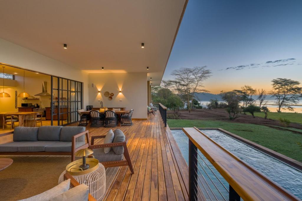 an open living room and deck with a view of the ocean at Rubi Ranch Lakehouses in Naivasha