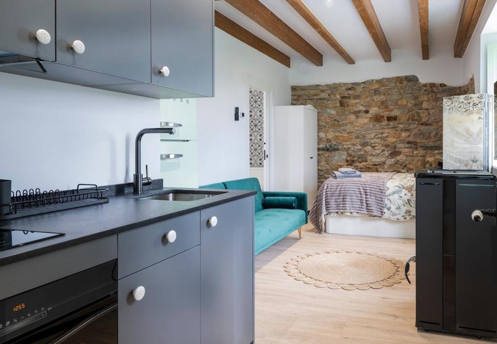 a kitchen with a sink and a couch in a room at El Sueño, Pilaro in Barres