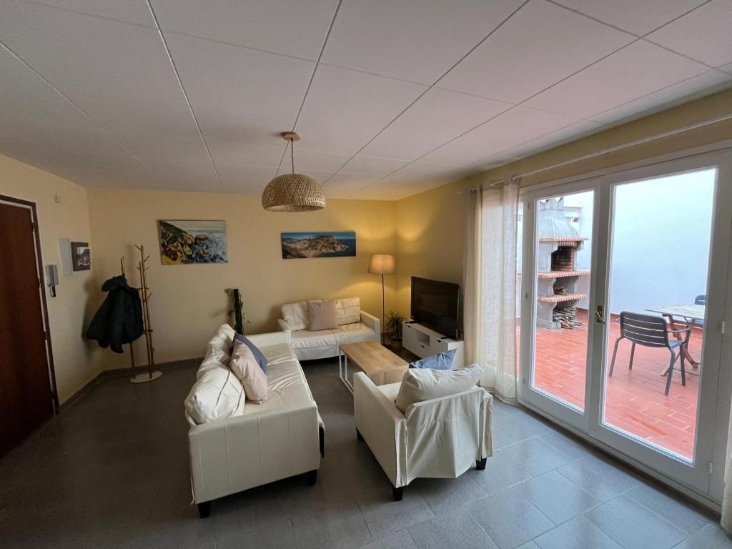 a living room with white furniture and a large window at Close to the beach duplex in Tossa de Mar