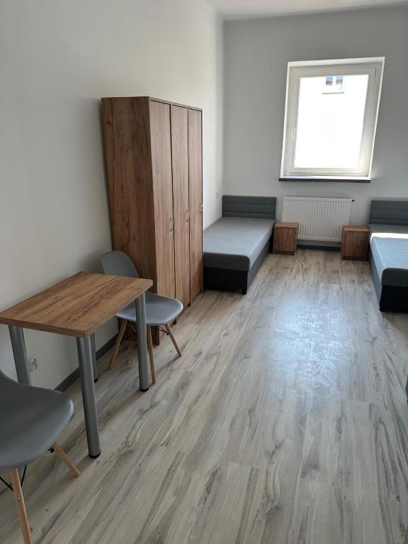 a room with a table and chairs and a desk at Mieszkateria in Piotrków Trybunalski