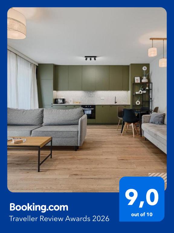 a living room with two couches and a kitchen at Fuzja II by LookAp in Łódź
