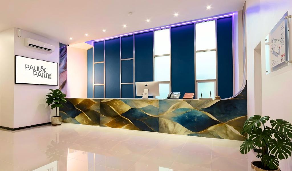 a lobby with blue and gold walls and a desk at Paul and Pam Hotel Bangkok in Bang Kapi