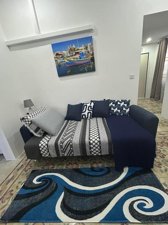 a couch in a living room with a rug at Coral Reef Charming studio by the three old cities in Cospicua