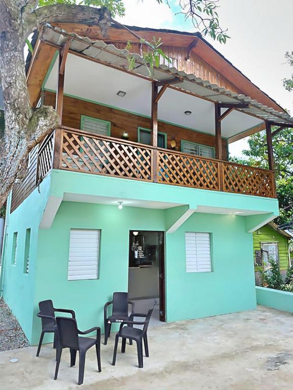 a house with a deck and chairs in front of it at Casa Mar y Campo in San Felipe de Puerto Plata