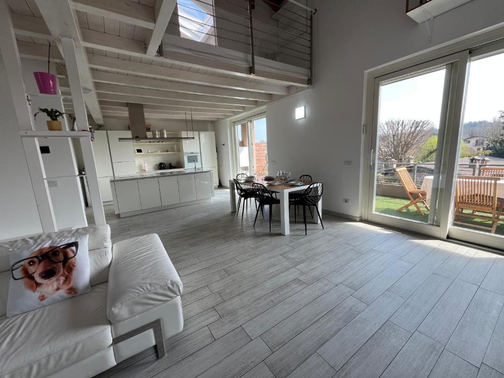 kuchnia i salon ze stołem i krzesłami w obiekcie Charme Lake Loft w mieście Ispra