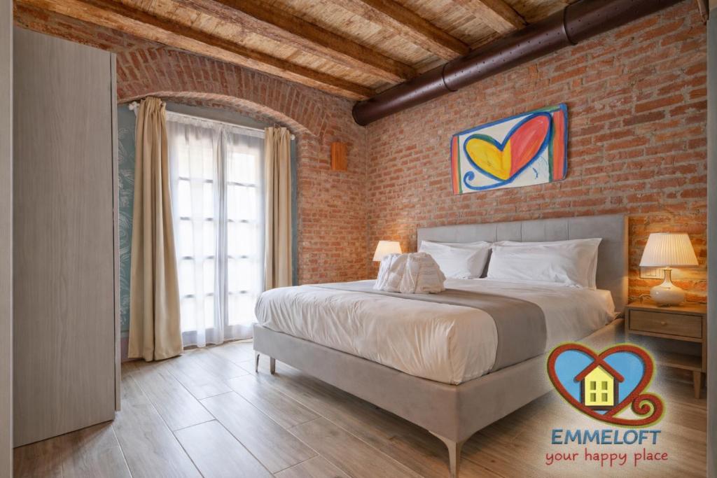 a bedroom with a bed and a brick wall at Emme Loft I New Moon - Stylish Apartment with Balcony in Milan