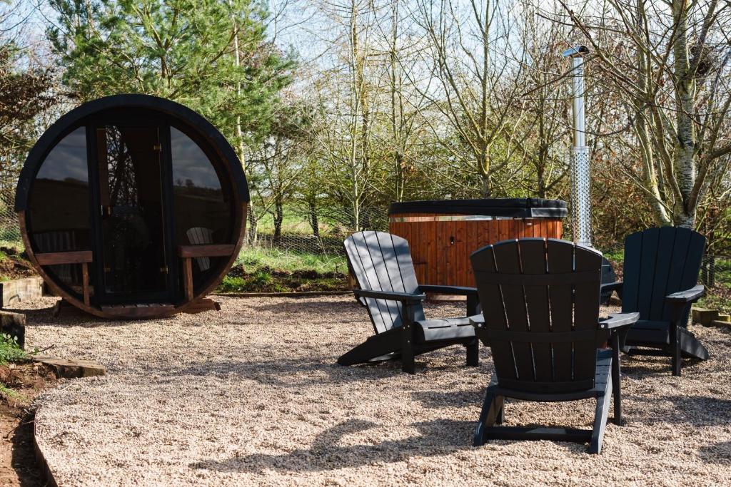 a group of chairs and a table and a barrel at Pheasant Lodge in Little Bytham