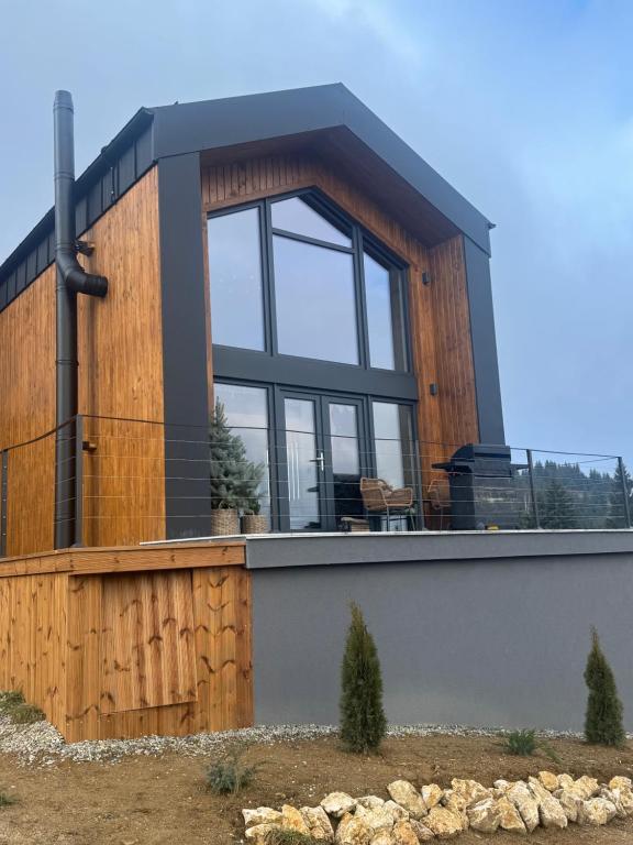 a house with a large window on the side of it at Altitude Escape Retreat in Fundata