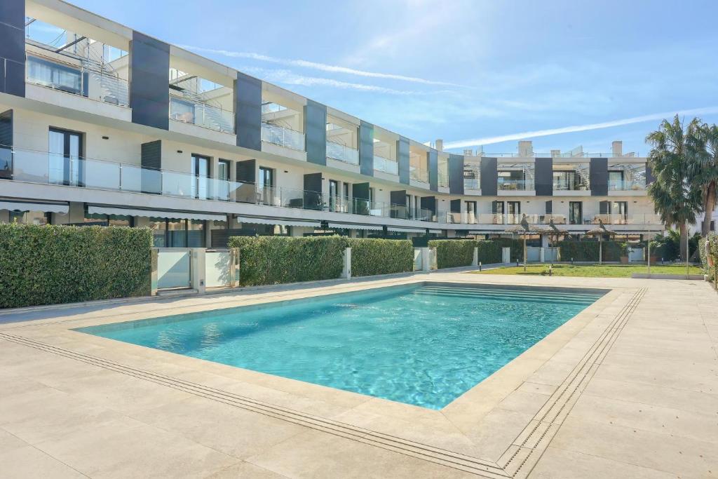 a swimming pool in front of a building at La Perla 3 in El Port