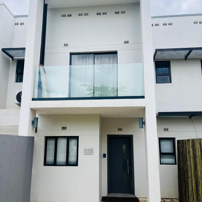 a white house with a black door at 219 Contours Luxury Apartment in Victoria Falls