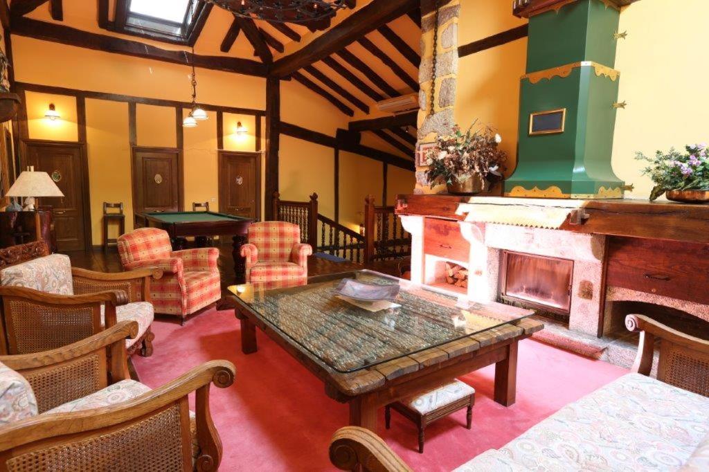a living room with a fireplace and a table at Posada Palacio de Beola by Clabao in Almándoz