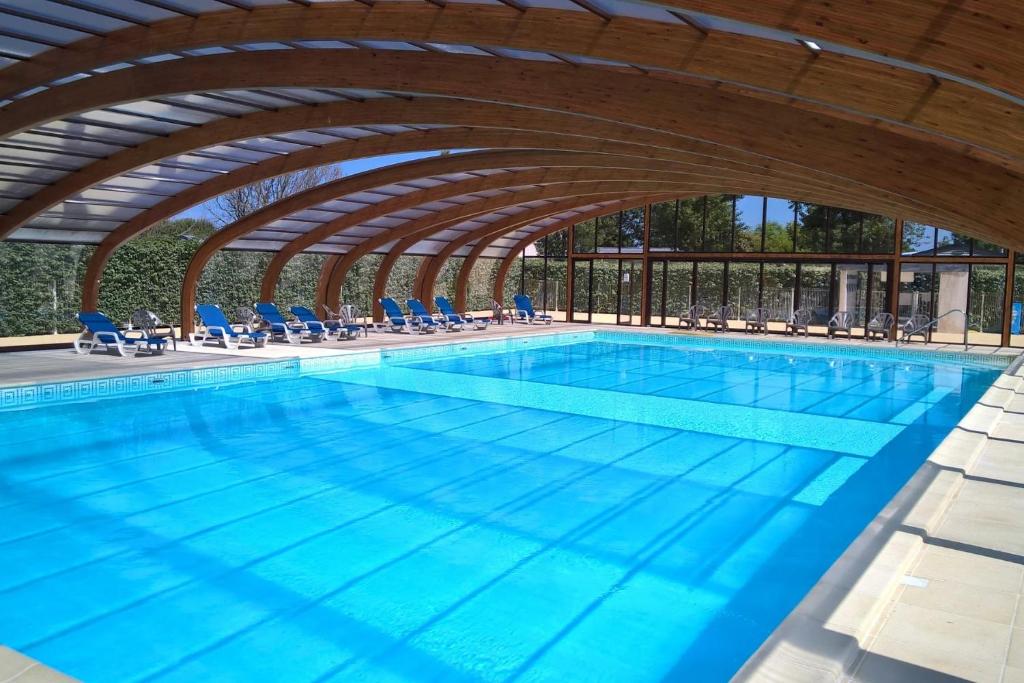 a large swimming pool with blue chairs at Camping 3 étoiles - Piscine - ccbffbc in Saint-Denis-dʼOléron