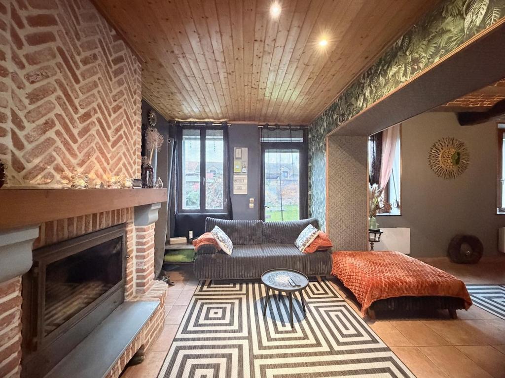 a living room with a couch and a fireplace at Suite Home in Crespin