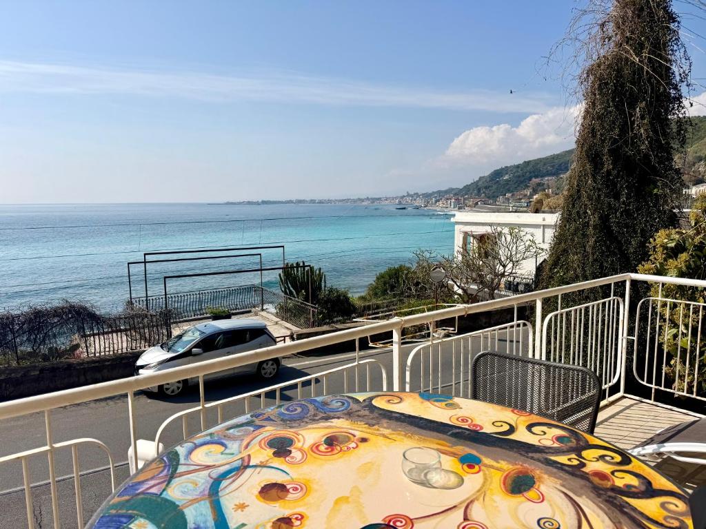 a table on a balcony with a view of the ocean at Blue Lagune Taormina Mare in Taormina