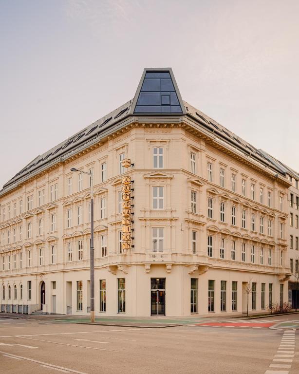a large white building with a black roof at The Companion Vienna in Vienna